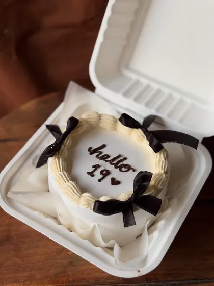 A Pinterest-inspired bento cake to celebrate turning 19. The black bows on a cream-colored cake create a chic, timeless look.