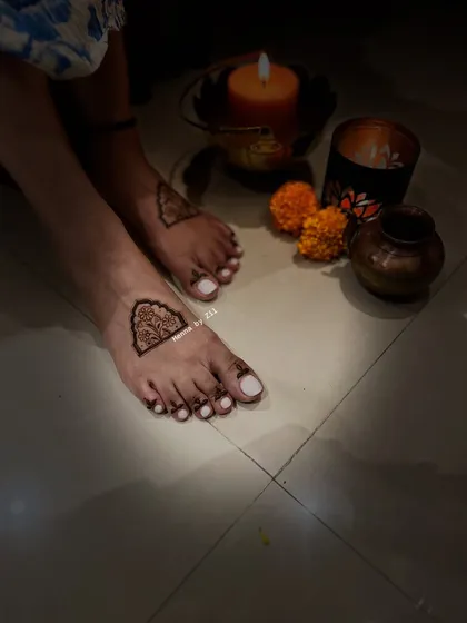 Another shot of this minimal foot mehendi, showing how beautifully it is framed by the candlelight.