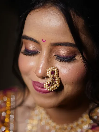 A serene moment. The shimmer on the eyelids catches the light beautifully, adding a touch of magic to this traditional Maharashtrian look.