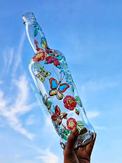 There's something magical about how glass paints catch the light. I painted these colorful butterflies on a clear bottle to create a stained-glass effect that looks absolutely stunning in the sunlight.