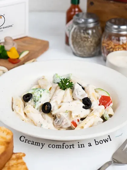 A close-up of our creamy White Sauce Pasta, showing the fresh vegetables and smooth, cheesy sauce. It's pure comfort in a bowl.
