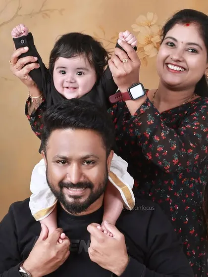 A family portrait with a 'Money Heist' twist. The parents and baby are all smiles, showing that our themed shoots can be fun for the whole family.