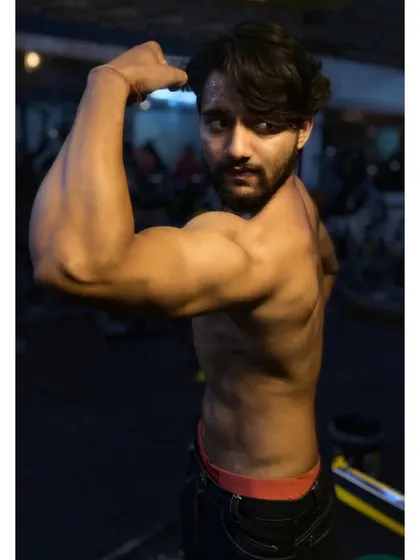 A client flexing his bicep. Building impressive arms is a common goal, and I provide the right exercises and techniques to achieve it.