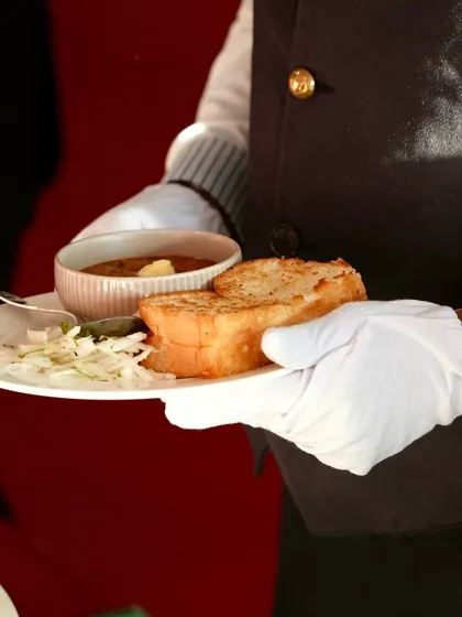 A server presents a plate of classic Pav Bhaji, complete with a dollop of butter. A taste of Mumbai's streets, served with five-star elegance.