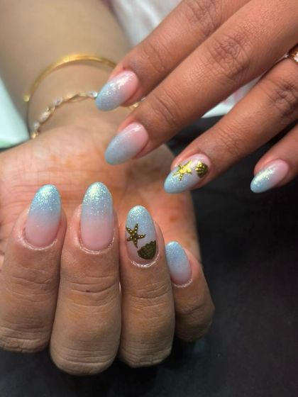 Another view of the beachy nails, showing the soft blend of the blue and nude glitter base.