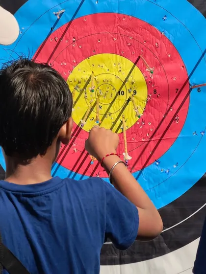 A young archer pulling his arrows from the target after a successful round at the Under 13 boys' selection trials.