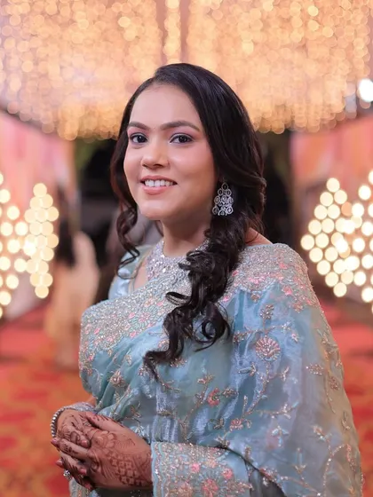 A close-up portrait of the guest in the blue saree. Her makeup is soft and pretty, with a focus on flawless skin.