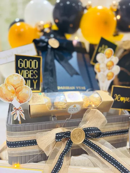 This shot highlights the thoughtful details, from the 'Good Vibes Only' tag to the carefully arranged sweets. Every element is chosen to inspire positivity and celebrate a new professional chapter.