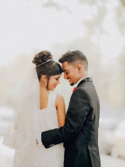 An intimate and classic couple portrait. The focus is on their gentle embrace and happy expressions, creating a timeless memory.
