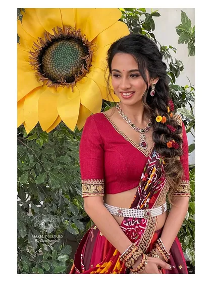 A close-up of Prathima's haldi look. The soft makeup and the intricate, colorful braid create a look that is both beautiful and perfect for a daytime celebration.