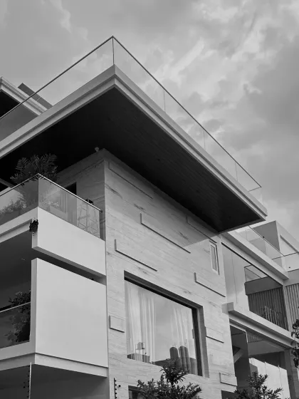 Step inside this elegant haven. This black and white image captures the powerful geometry and textural details of the facade, hinting at the carefully crafted spaces within.