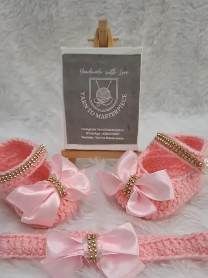 This pretty pink set features booties and a matching headband, both adorned with a soft pink satin bow with a sparkly, stone-studded center.