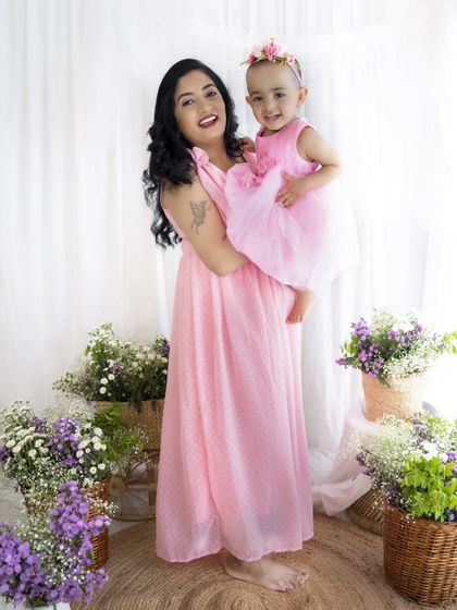A joyful mother lifts her daughter in the air, a perfect capture of love and happiness for Mother's Day.