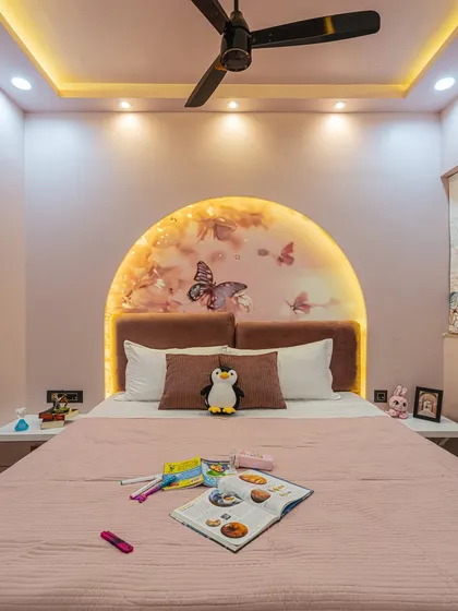 When a client's daughter wanted a pink room, I made sure to create a space she would love. This bedroom features a custom-arched headboard with butterfly wallpaper and soft backlighting, creating a dreamy and magical atmosphere.