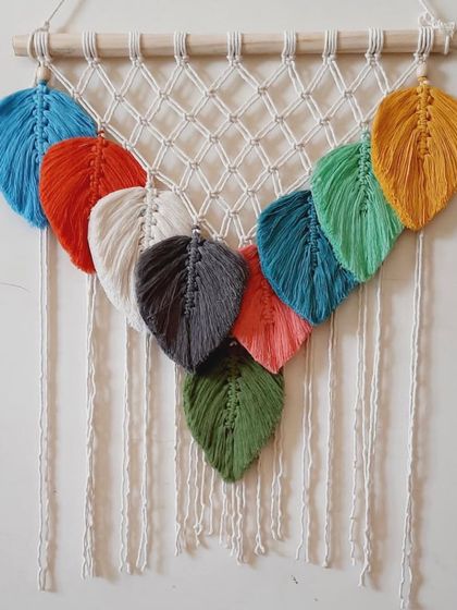 For those who love color, this wall hanging features a rainbow of macrame leaves. Each leaf is individually knotted and attached to a netted macrame panel.