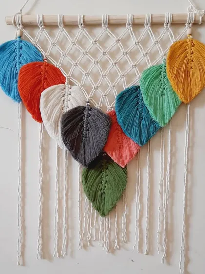 For those who love color, this wall hanging features a rainbow of macrame leaves. Each leaf is individually knotted and attached to a netted macrame panel.