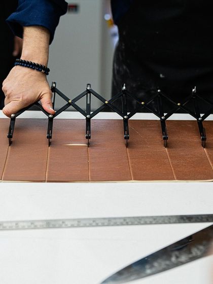 The precision of a master. Chef Antonio Bachour uses a dough divider to ensure perfect, uniform cuts for his pastries.