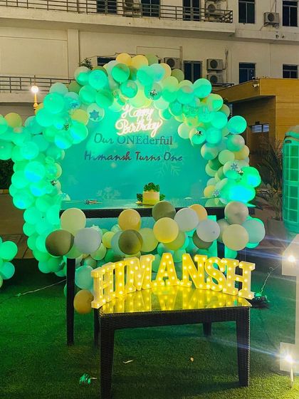 Another night shot of the modern pastel birthday decor, highlighting the glowing 'Happy Birthday' sign and the illuminated name and number.