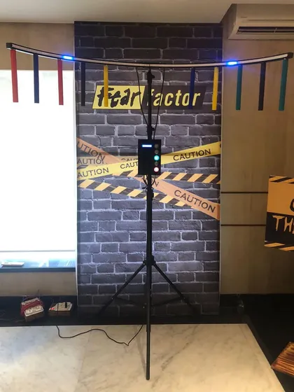 This is our 'Catch the Baton' or 'Fear Factor' reflex game, set up against a themed backdrop. It's a simple yet challenging game that can be enjoyed by both kids and adults.