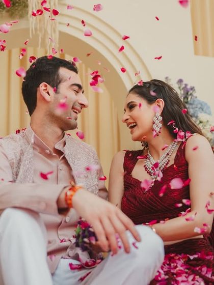 A candid, happy moment between the couple amidst a shower of petals. These are the quiet, joyful memories that form the heart of their wedding story.