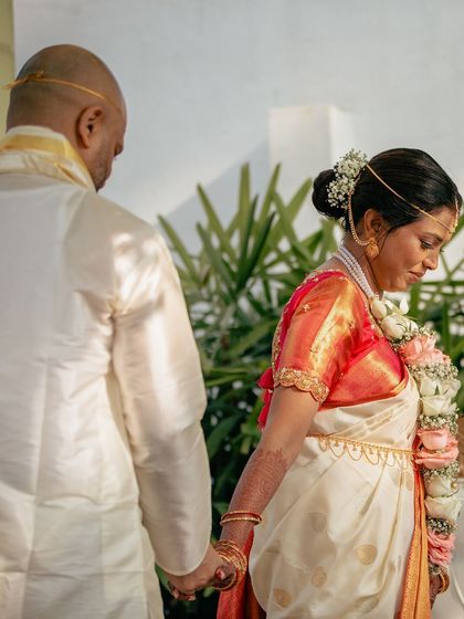 A close-up of a couple holding hands during their ceremony. This photo highlights the blend of cultures and the beautiful details of their wedding attire.