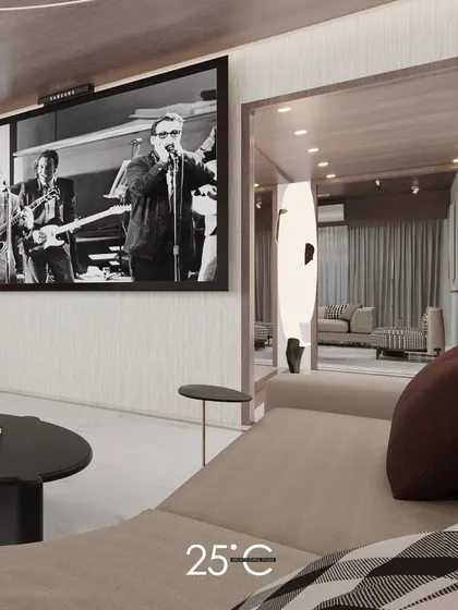 A glimpse into a sophisticated apartment living area, featuring a large-screen television and a comfortable, modern chaise lounge. The design focuses on creating a perfect space for cinematic experiences at home.