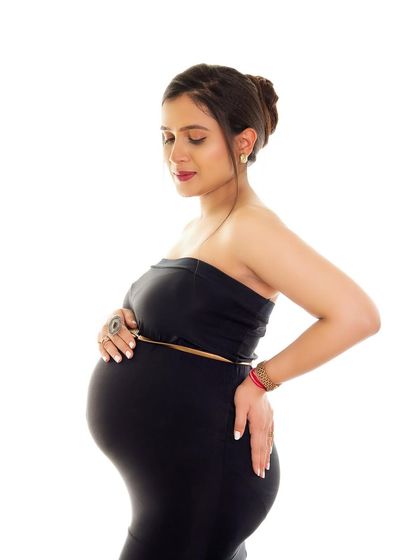 A simple and elegant portrait in a black two-piece outfit. This minimalist style is perfect for creating timeless images that focus on the beauty of your pregnancy.