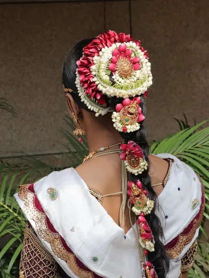A view of the back, showcasing the elaborate floral hair arrangement, a masterpiece of traditional hairstyling.
