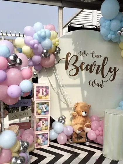 This outdoor baby shower setup shows a full view of the "We Can Bearly Wait" theme in a pastel palette. The decor is set against a striking black and white floor, making the colors pop.