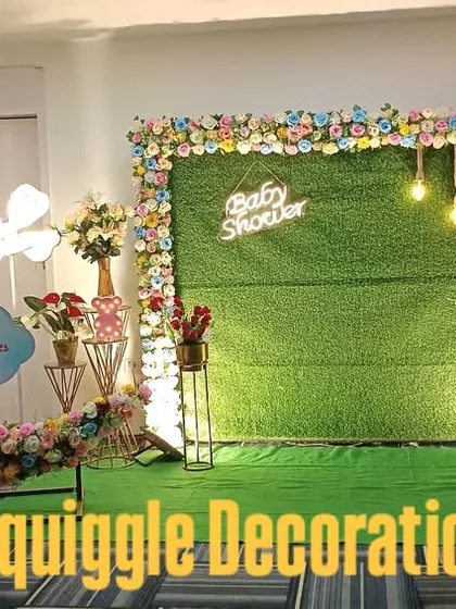 A beautiful and unique baby shower decoration with a floral crescent moon prop set against an artificial grass backdrop. This setup combines natural and whimsical elements, including 'Boy' and 'Girl' cutouts, for a memorable celebration for the parents-to-be.