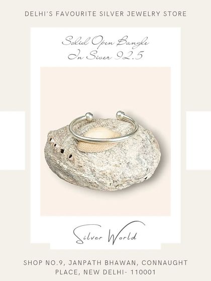 A solid open bangle with simple ball ends. This is a classic, minimalist piece that is perfect for everyday wear and stacking.