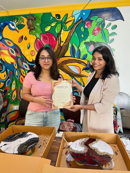 Two beautiful resin art clocks, one with a marble effect and the other with a geode design, created by this talented participant during our workshop.