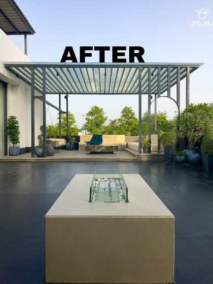 This "after" shot showcases the finished look of a modern terrace. The design features a sleek fire pit, a large pergola with a glass roof, and minimalist furniture for a clean, contemporary feel.