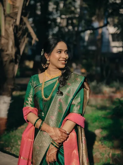 A beautiful portrait of the bride, with sunlight highlighting her radiant skin and elegant green saree.
