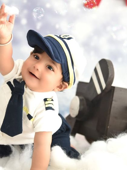 Reaching for the bubbles in our pilot-themed setup. It's the small, spontaneous moments like these that make for the most magical photos.