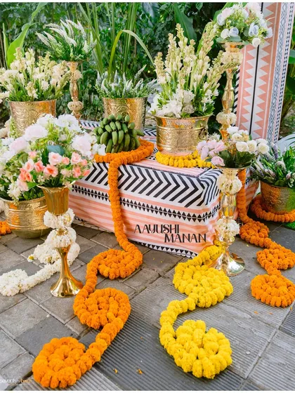 The beautiful Haldi decor, with marigold garlands and floral arrangements, setting a festive and colorful scene for the celebration.