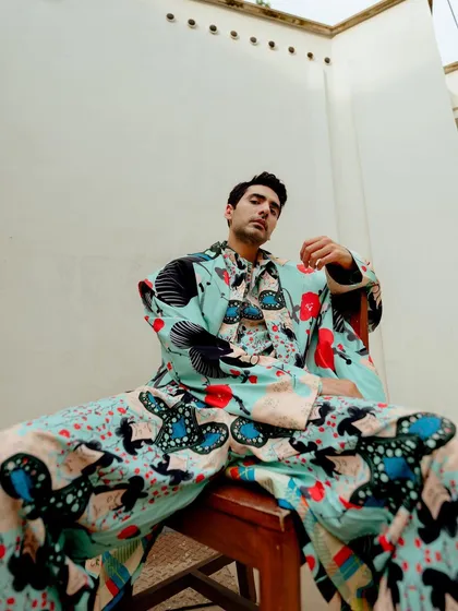 An editorial portrait of actor Ishwak Singh for Hindustan Times. The low-angle shot and vibrant, patterned suit create a powerful and confident image, showcasing a blend of personality and high fashion.