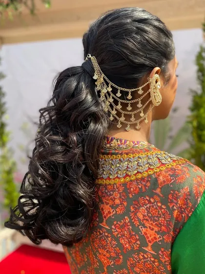 A modern twist on a classic ponytail. I created this textured, high-volume ponytail and integrated it with a stunning gold chain ear cuff accessory for a chic and edgy mehendi look that is both stylish and comfortable.