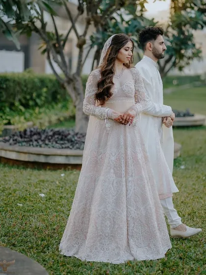 A full-length portrait of a couple in a beautiful garden setting. Her elegant gown and his classic sherwani are perfectly complemented by the natural surroundings, creating a graceful and timeless pre-wedding photograph.