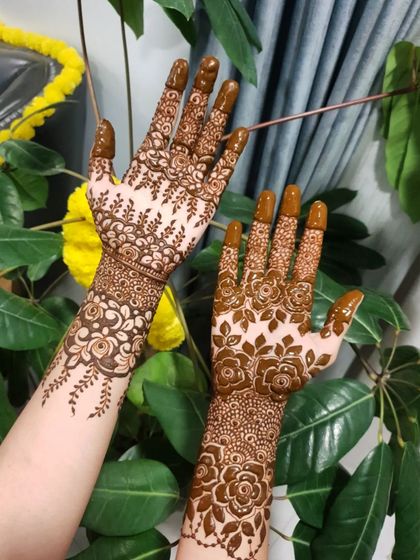 A floral party henna design with a mix of styles, including a delicate vine on the back of the hand.