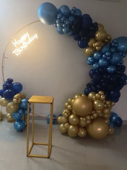 A stylish half-arch balloon decoration on a ring frame. The navy blue and gold chrome balloons create a sophisticated look, perfect for any adult celebration.