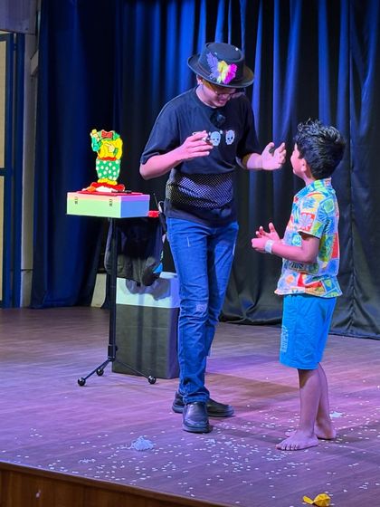 The moment of reveal in a magic trick, with a student volunteer looking on in amazement. These are the moments of pure joy we aim to create.