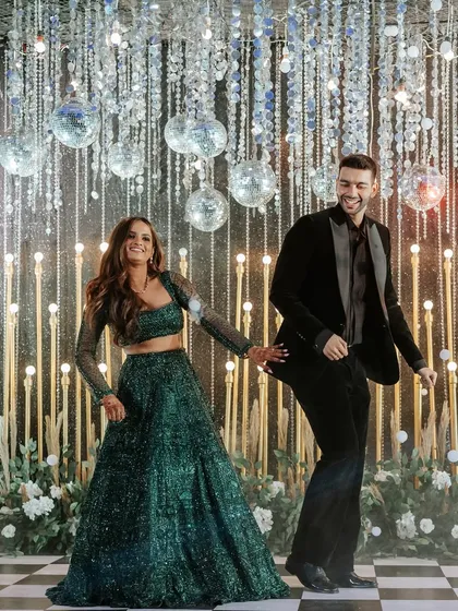 We turn the Sangeet night into a full-blown fairytale. This couple's first dance was set against a backdrop of sparkling disco balls and a classic checkered dance floor, creating a scene of pure energy and joy.