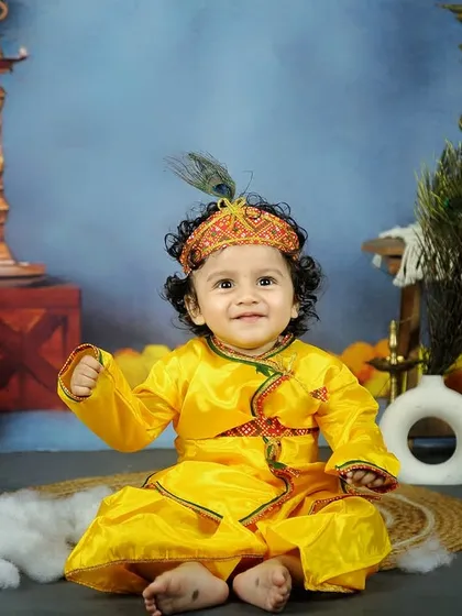 Another adorable shot from our Janmashtami series. This little Krishna is all smiles, sitting amidst peacock feathers and traditional lamps.