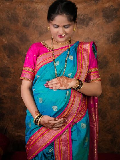 A full-length portrait showcasing the beautiful drape of the saree. I guide my clients with poses that are both flattering and comfortable during their pregnancy photoshoot.