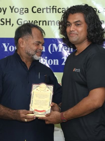 A judge receives a plaque from our chief guest, a moment of mutual respect among leaders in the yoga community.