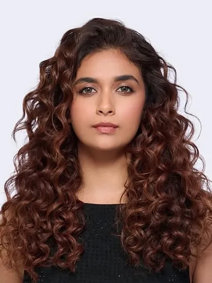 A beautiful transformation for actress Keerthy Suresh, showcasing our Iconic Browns color service. We enhanced her natural curls with rich, warm tones for a healthy, radiant finish.