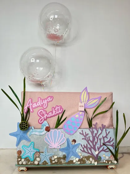 A separate, dedicated 'Under The Sea' hamper for Aadiya Shakti. This gift features a personalized nameplate, a mermaid tail, and a seascape base with starfish and shells.