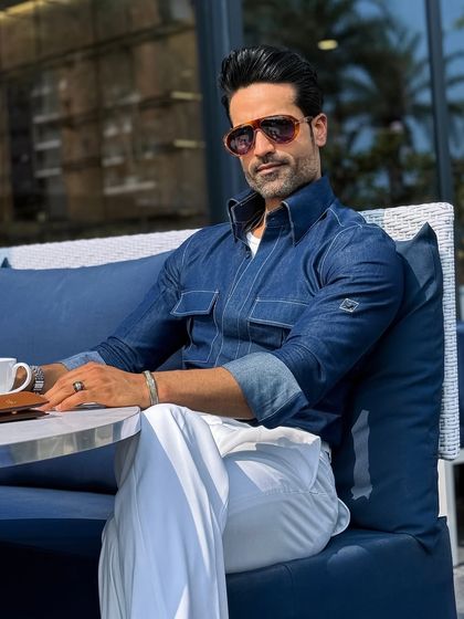 A closer look at the denim shirt, highlighting the contrast stitching and the quality of the indigo fabric. It’s a modern classic, tailored to perfection.