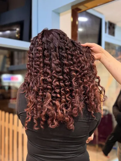 One of our best looks of 2024. This client is rocking beautifully defined curls with a stunning red-brown color.
